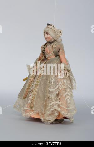 A marionnette, Duchesse Rosaura, from the collection of Léon Guillot de Saix, a French collector, created in 1701, featuring a salmon-pink silk dress with beige lace, a white silk underskirt, and a white wig, holding a fan in her right hand. Stock Photo