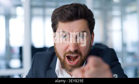 Close up negative angry Caucasian middle-aged business man talking with aggression looking at camera senior businessman mature male entrepreneur talk Stock Photo