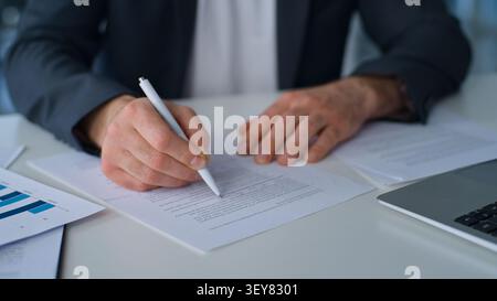 Unrecognizable business man bookkeeper analyst holding papers male hands writing unknown Caucasian businessman write signing documents working Stock Photo