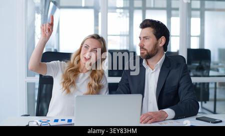Two business people talking gesturing with hands work occupation brainstorming at office conference with laptop and diagrams Caucasian businessman Stock Photo