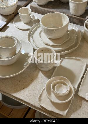 Handmade ceramic tableware set on wooden table showcasing artisanal craftsmanship. Mobile photo Stock Photo