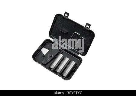 An open black plastic case with shotgun choke tubes and a wrench on a white background. Stock Photo