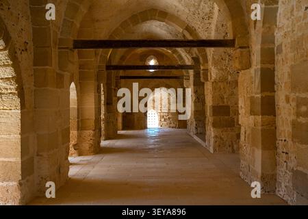 Interior view of a long, narrow stone barrel-vaulted hallway with side rooms inside the Qaitbay Citadel in Alexandria, Egypt Stock Photo