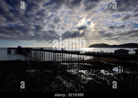 Dramatic clouds over Llandudno Pier and The Little Orme, Llandudno town, Conwy, North Wales, Britain. Stock Photo