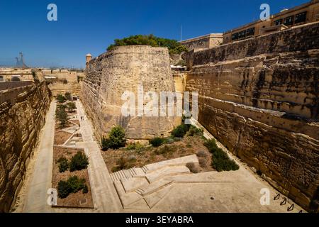 High-angle view into the massive defensive ditch and bastions of Valletta City Gate fortifications, Malta Stock Photo