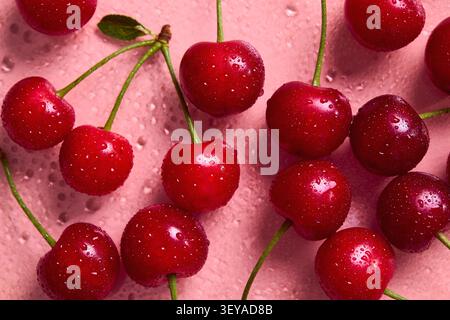 Fresh sweet cherries with water droplets on a pink background Stock Photo