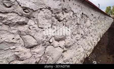 Old weathered whitewashed stone wall of Trokiele church showing signs of deterioration Stock Photo