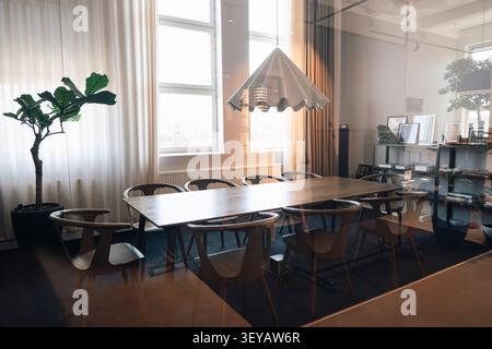 Empty modern conference room with long wooden table and chairs Stock Photo