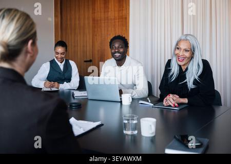 Diverse coworkers laughing during business presentation in office Stock Photo