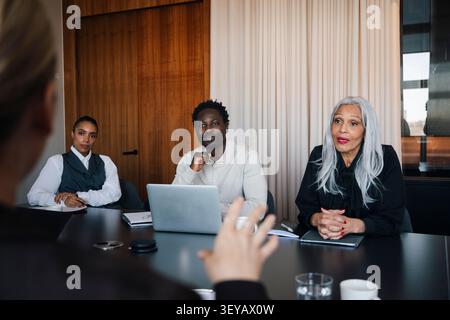 Group of serious corporate workers having discussion in meeting room Stock Photo