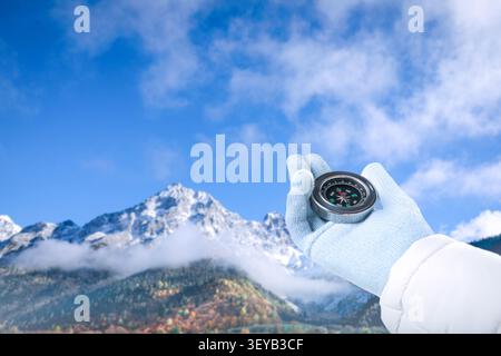HIker holding compass in hand against mountains, closeup Stock Photo