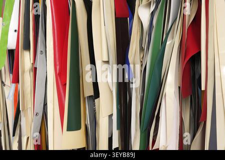 Various textured fabric and material samples in a range of colors hanging vertically, offering options for textile pattern and design projects Stock Photo