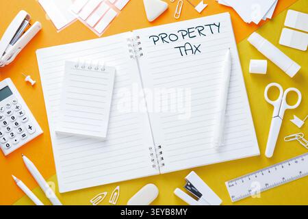 Property tax. Notebook with words and other stationery on colorful background, flat lay Stock Photo