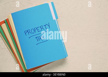 Property tax. Folders with documents on wooden table, top view. Space for text Stock Photo