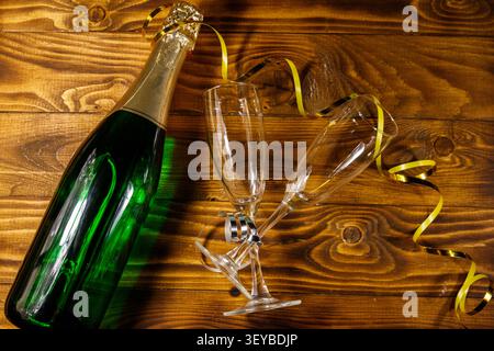 Champagne bottle and two empty champagne glasses on wooden background. Top view Stock Photo