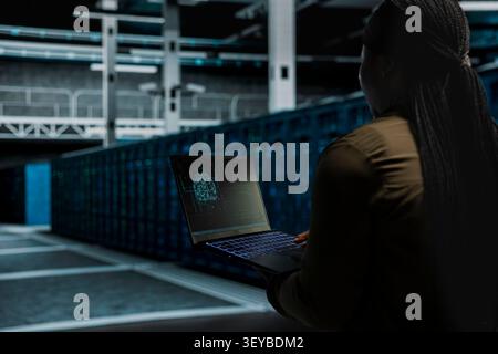 Computer scientist works with a computer workstation in a server hub to support artificial intelligence systems. Stock Photo