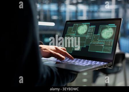 Data center technician uses a desktop computer in a data center to monitor equipment, manage workflows, and support reliable infrastructure. Stock Photo