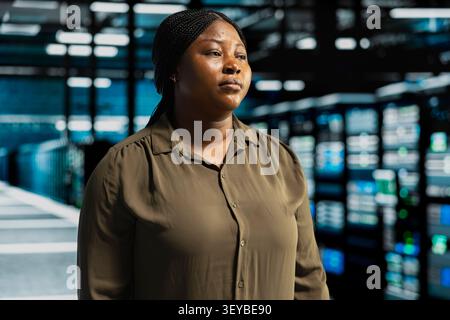 System operator uses a digital device in a data center to monitor equipment, manage workflows, and support reliable infrastructure. Stock Photo
