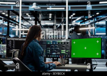Data center engineer works with a chroma key computer, using an editable screen to manage technical tasks. Stock Photo