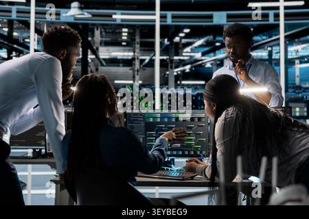 Data center programmer uses a computer to investigate neural network configurations, working with AI technology and high performance systems. Stock Photo
