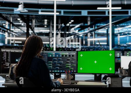 Data center engineer works with a chroma key computer, using an editable screen to review performance data. Stock Photo