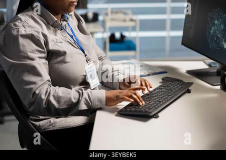 System administrator uses a computer to run diagnostics, update servers and check infrastructure performance. Stock Photo