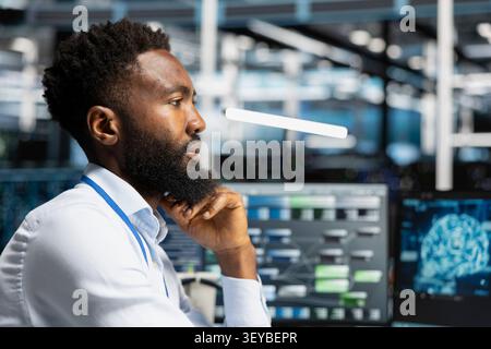 Server facility workplace technical specialist applying AI neural network models technology. Stock Photo