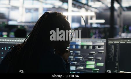 Data center engineer manages databases supporting AI applications and data mining in a server facility. Stock Photo