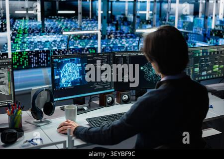 System administrator works on a computer to monitor AI systems, neural networks and server infrastructure. Stock Photo