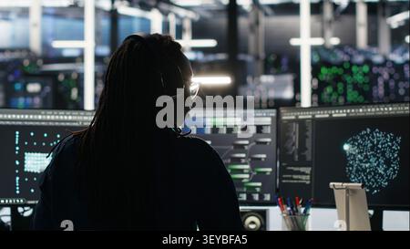 Data center programmer reviews artificial intelligence systems and machine learning processes inside a data center. Stock Photo