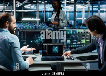 Programmers use an AI language model assistant in a server hub to handle infrastructure maintenance. Stock Photo
