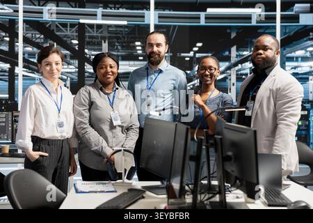 Positive engineering team in data infrastructure center managing server virtualization, running scripts. Stock Photo