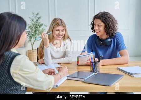Happy teenage students working on project together Stock Photo