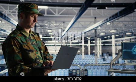 Military IT specialist reviews reconnaissance information with AI software in a server room environment. Stock Photo