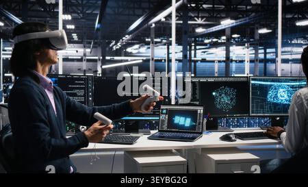 Software programmer working with virtual reality headset in data infrastructure center. Stock Photo