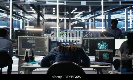 Irked high tech server room IT specialist smashing desk, upset by faulty equipment. Stock Photo