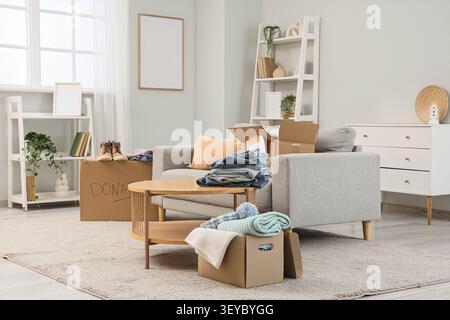 Living room with donation boxes filled with clothes and shoes Stock Photo