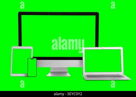 Multiple digital devices with green screens on green background Stock Photo