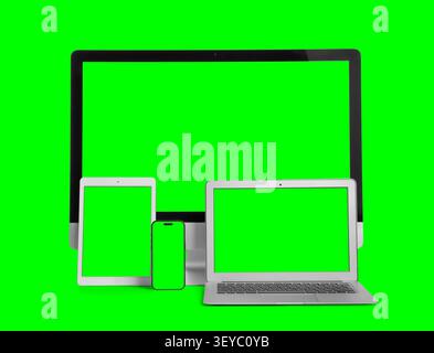 Multiple digital devices with green screen displays Stock Photo