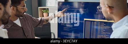 Adult Men Reviewing Software Code on Monitor in it Office Stock Photo
