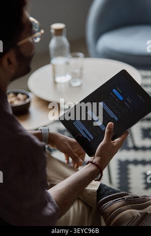 Adult Man Reviewing Productivity Analytics on Tablet in IT Office Stock Photo