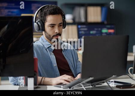 Man Working on Laptop in Information Technology Office Stock Photo
