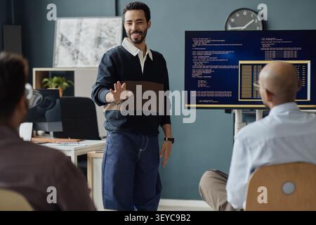 Adult Man Presenting Software Code during Team Meeting Stock Photo