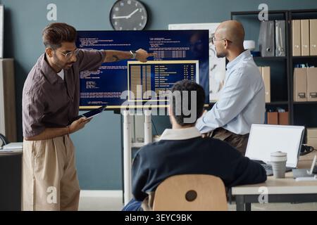 Diverse Men Reviewing Software Data during IT Office Meeting Stock Photo