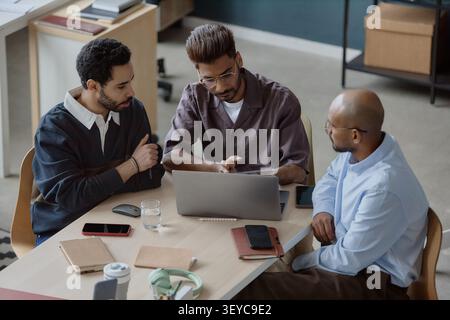 Diverse Businessmen Collaborating on Project in Office Stock Photo