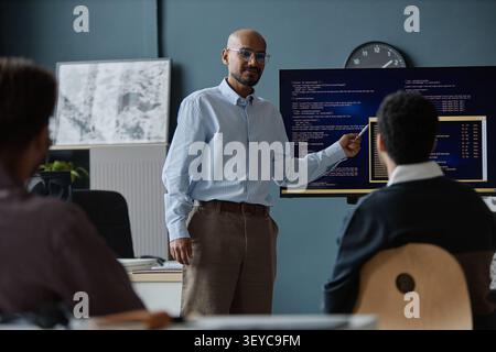 Middle Aged Man Presenting Software Code during Office Meeting Stock Photo