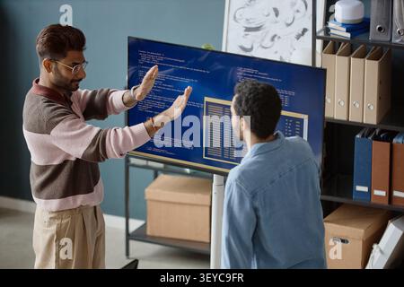 Adult Men Reviewing Software Code in Information Technology Office Stock Photo