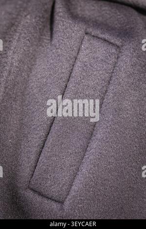Dark wool coat pocket detail closeup with soft texture in studio lighting vertical composition Stock Photo