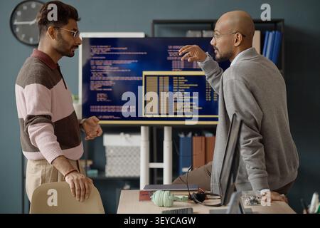 Adult Men Discussing Software Development Strategy in IT Office Stock Photo