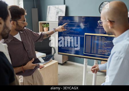 Diverse Men Reviewing Software Code in Information Technology Office Stock Photo